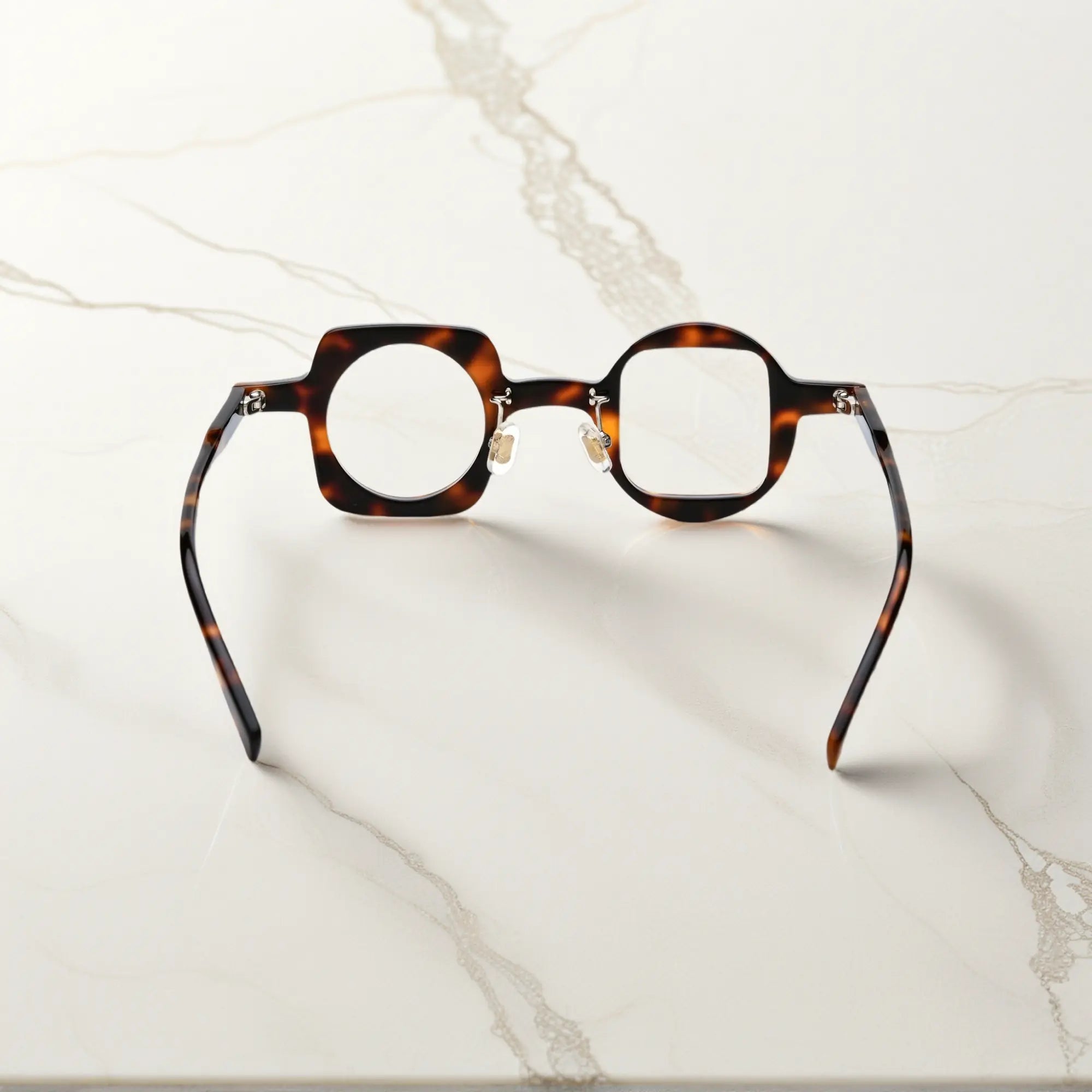 Back view of VoyueLens tortoise asymmetrical glasses with polished acetate finish, silicone nose pads, and durable standard metal hinges.
